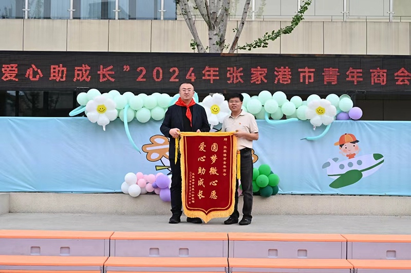 東萊小學校長蘇海峰代表全校師生向市青年商（shāng）會贈（zèng）送錦（jǐn）旗（qí）